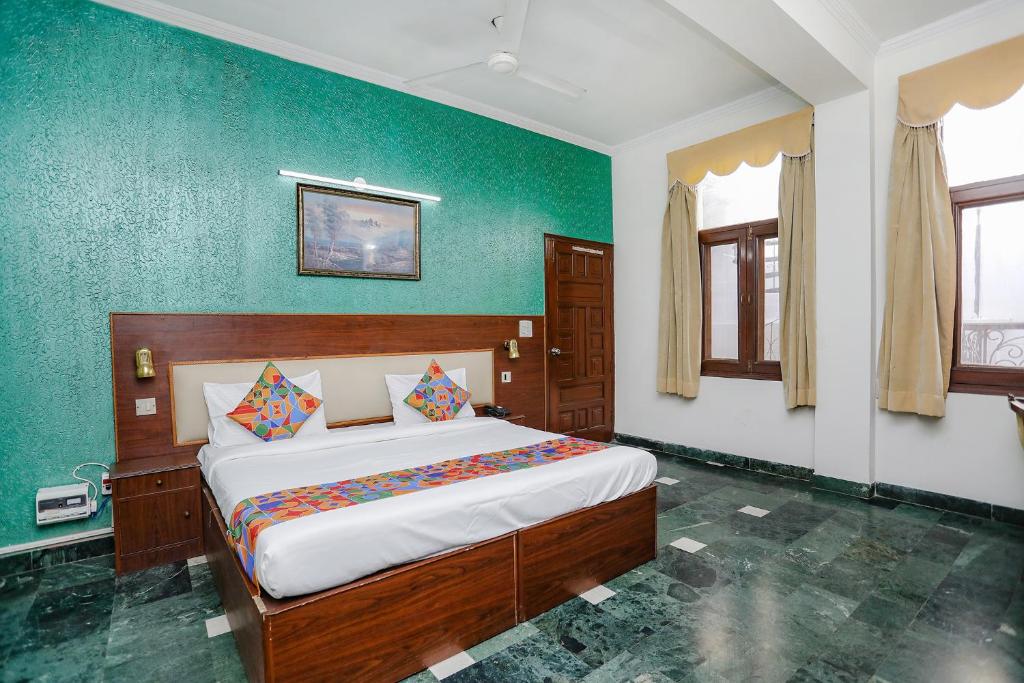 um quarto com uma cama grande e paredes verdes em FabExpress Primero I em Gurgaon
