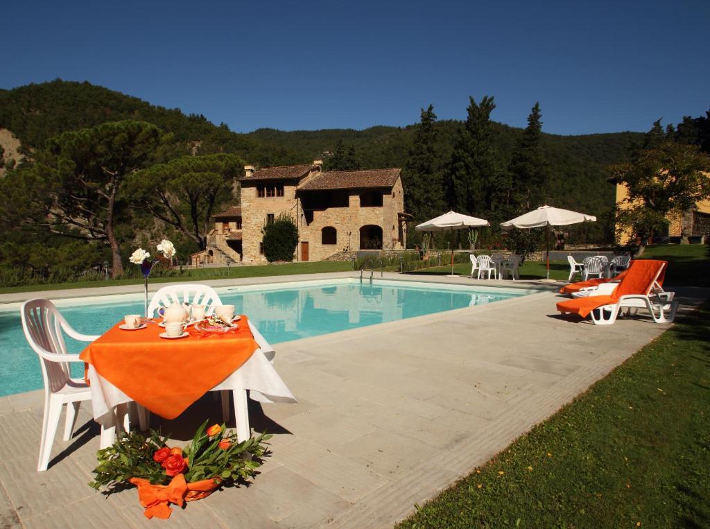 uma mesa e cadeiras ao lado de uma piscina em Tenuta Poggio Marino em Dicomano