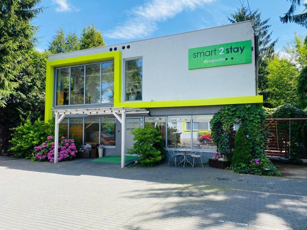un magasin avec un bâtiment jaune et blanc avec des plantes dans l'établissement Smart2Stay Magnolia, à Varsovie