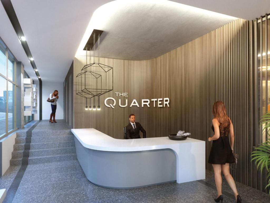 a man and a woman standing at a reception desk in a lobby at The Quarter Apartments in Cape Town