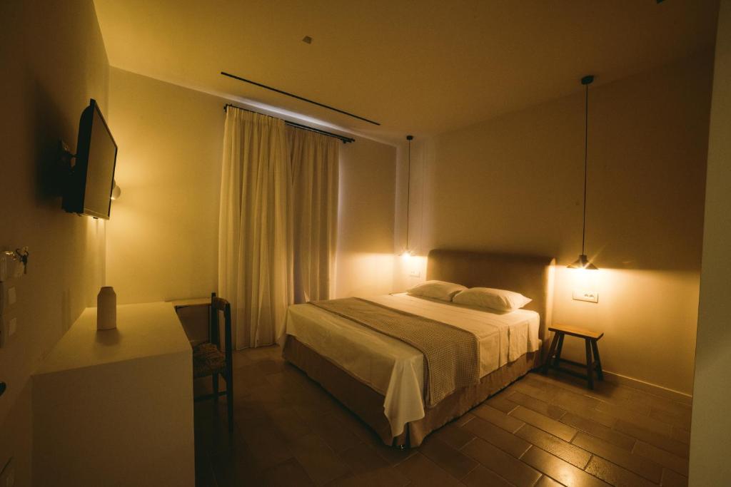 a bedroom with a bed and a table and lights at Yasemi in Argostoli