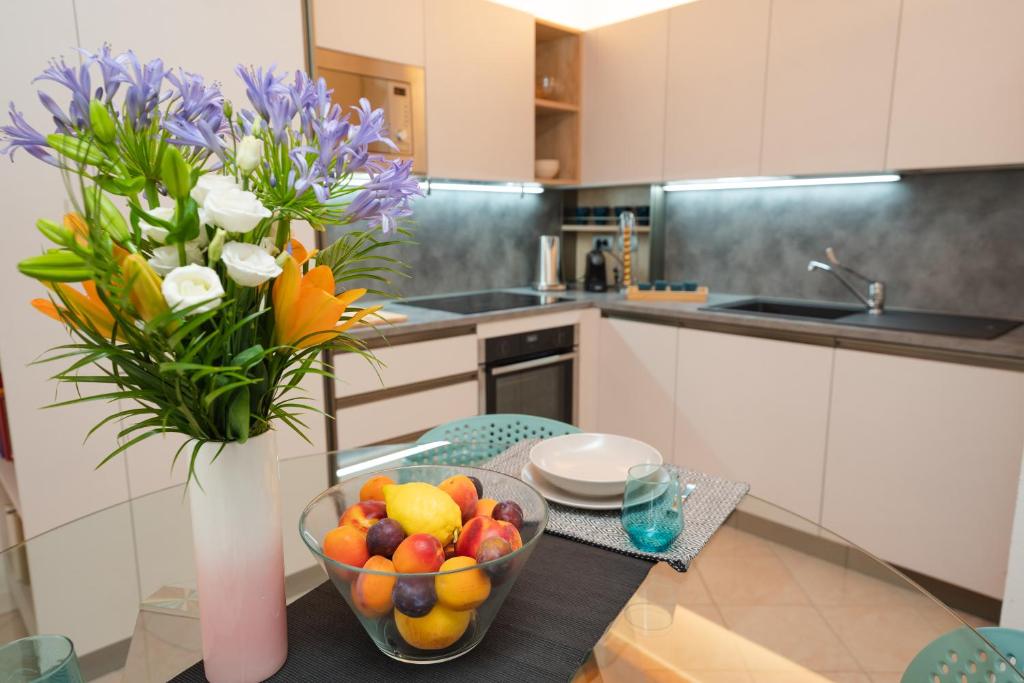 kuchnia z wazonem kwiatów i miską owoców w obiekcie Appartamento La Piazzetta w mieście Carpi