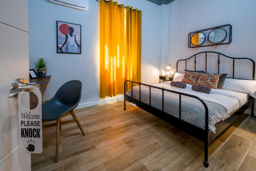 1 dormitorio con cama, escritorio y silla en The Venue Hostel Boutique, en Valencia