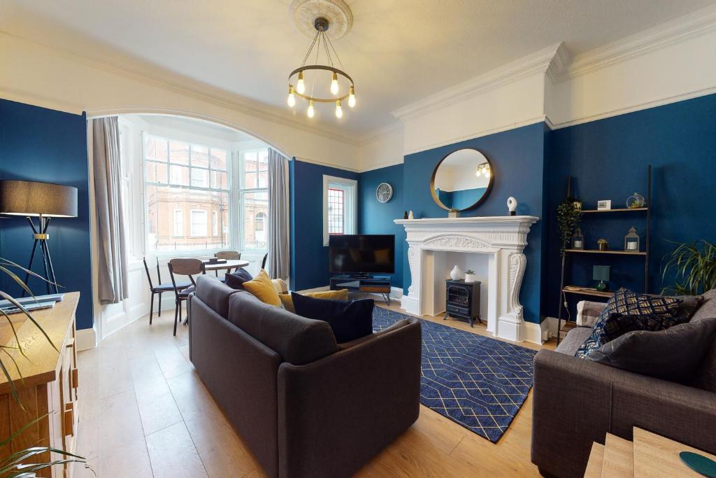 a living room with blue walls and a fireplace at No10 Seaside Apartment - Ground Floor Apartment in Scarborough