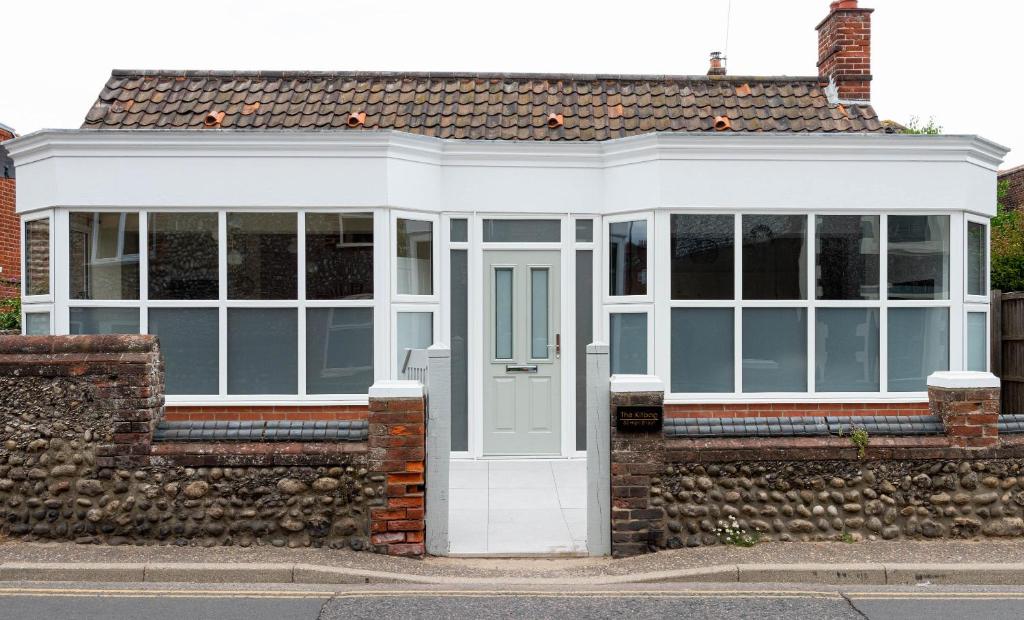 a house with a white door and windows at The Kitbag in West Runton