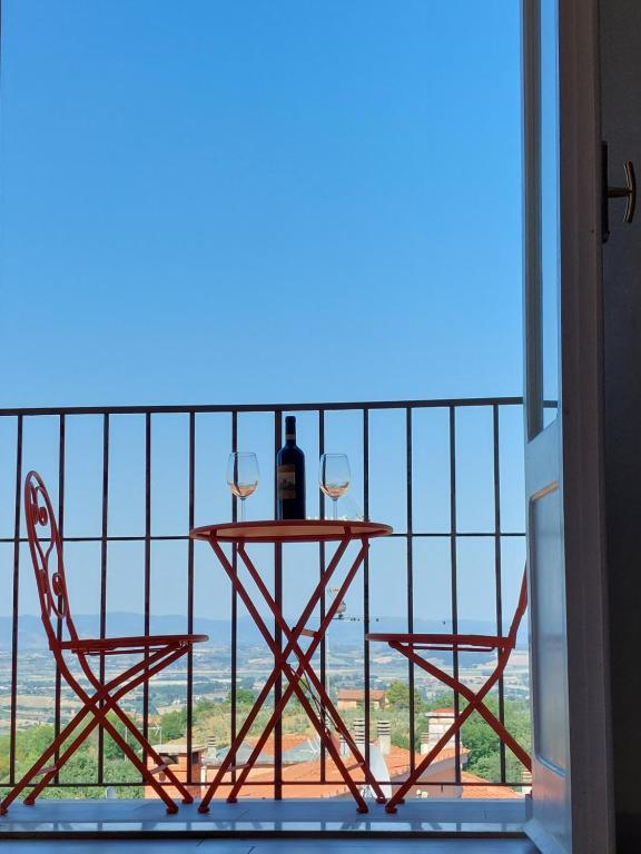モンテプルチャーノにあるappartamento la crocettaのバルコニーにテーブルとワイン2杯