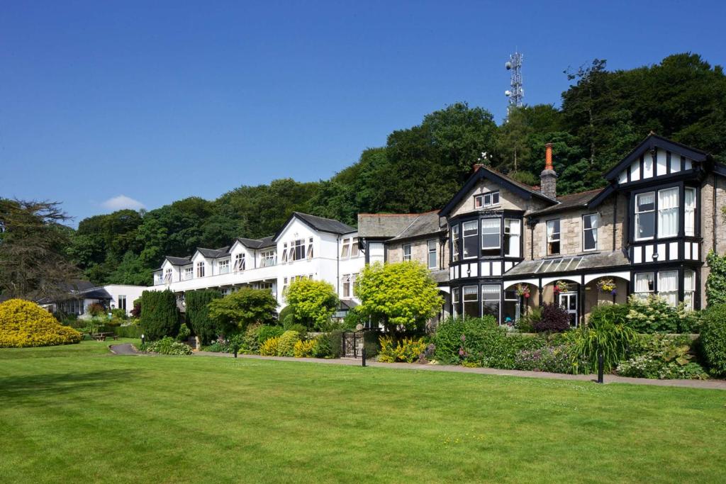 a large house with a lawn in front of it at Castle Green Hotel In Kendal, BW Premier Collection in Kendal