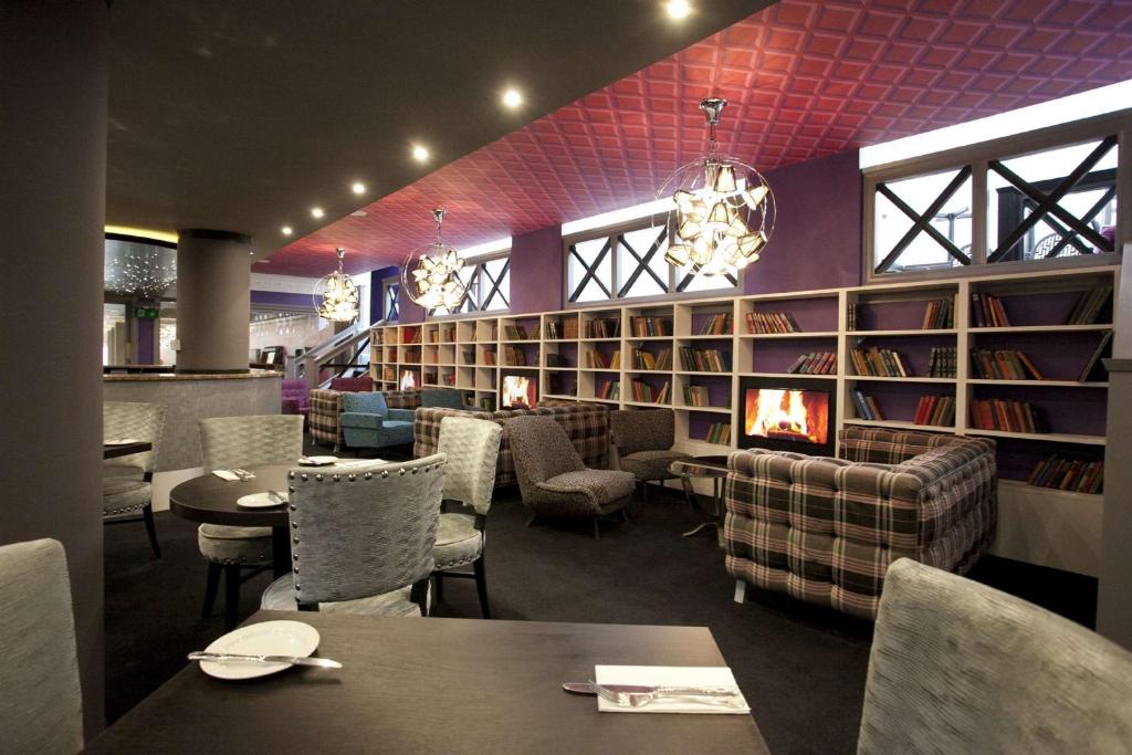 un restaurante con mesas, sillas y libros en St James Hotel; BW Premier Collection, en Nottingham