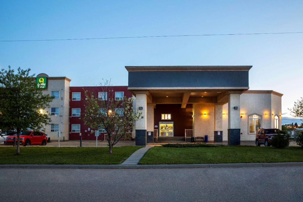 a building with a parking lot in front of a building at Quality Inn & Suites in Whitecourt