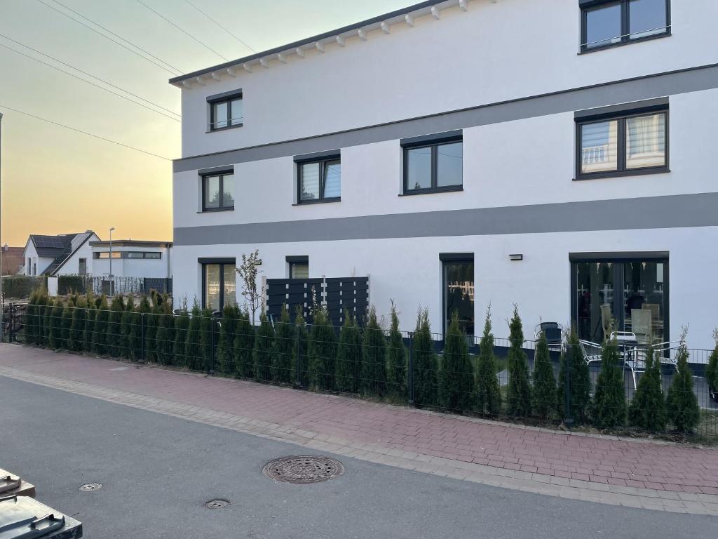 a white building with a fence in front of it at Luxusvilla Neubau 2 in Oberasbach