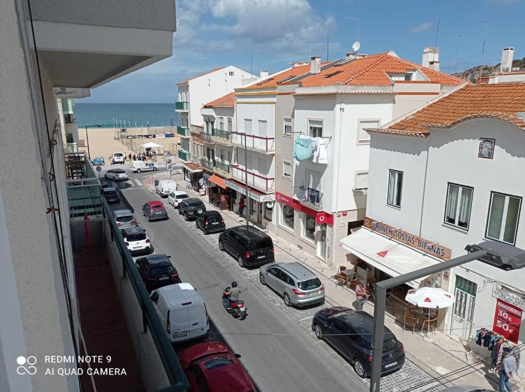 a view of a street with cars and buildings at Sol e praia in Nazaré