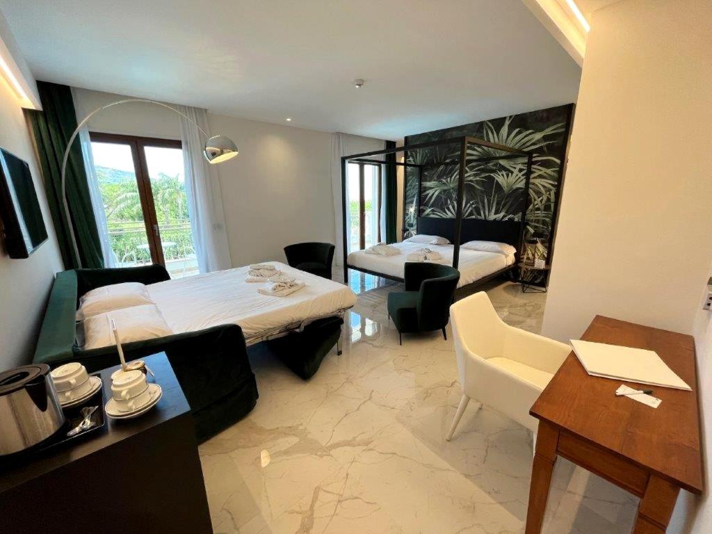 a hotel room with two beds and a desk at Hotel Alpha in Sant'Agnello