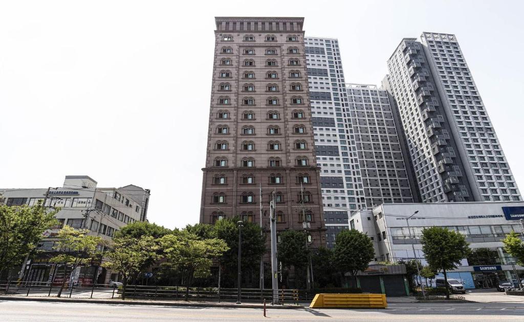 a tall building in a city with tall buildings at Doksan 3S Hotel in Seoul