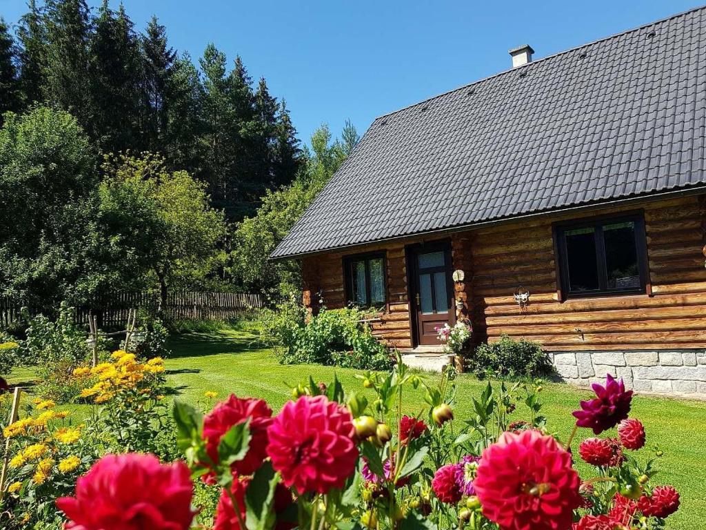 a log cabin with flowers in front of it at Srub Karpatský 