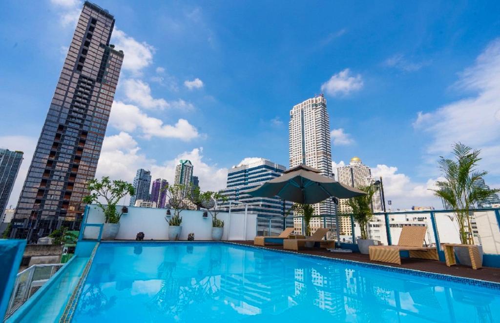 een zwembad met een skyline van de stad op de achtergrond bij Sapphire hotel Silom Bangkok in Bangkok