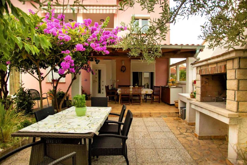 a patio with a table and chairs and a house at Apartments Ulika in Rovinj