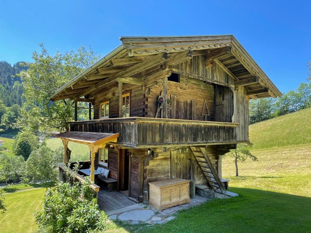 eine Blockhütte mit einer Veranda und einer Treppe zum Dach in der Unterkunft Chalet Troadkasten by Interhome in Dorf