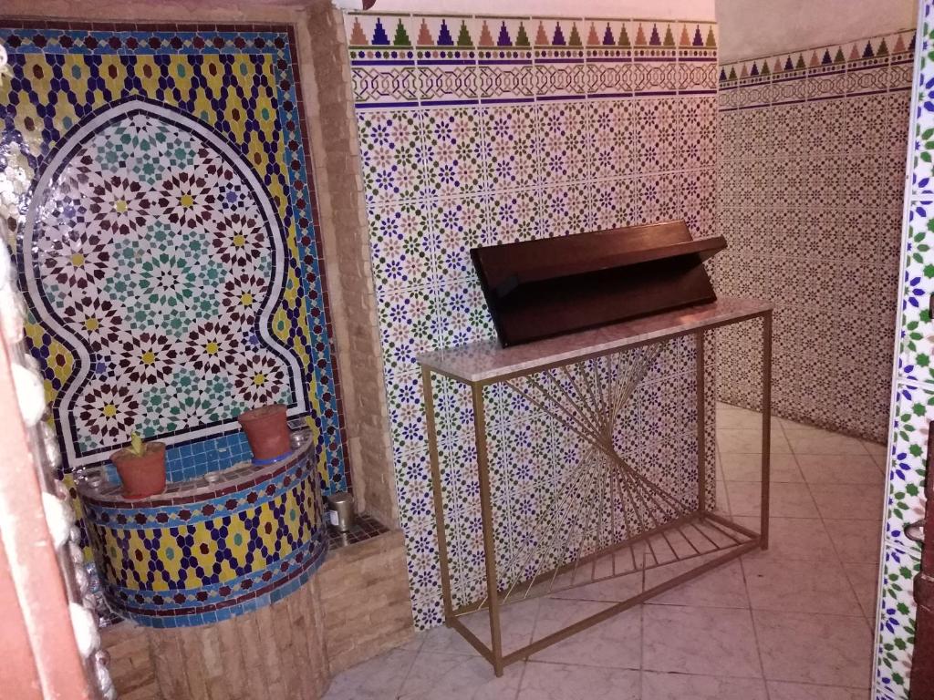 een badkamer met een mozaïekmuur met een plank en een tafel bij Dar Sam - Purple Room in Rabat