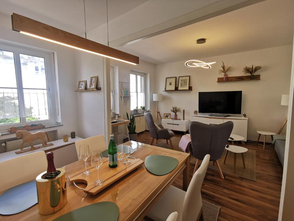 a dining room and living room with a table and chairs at Quirin in Neuss