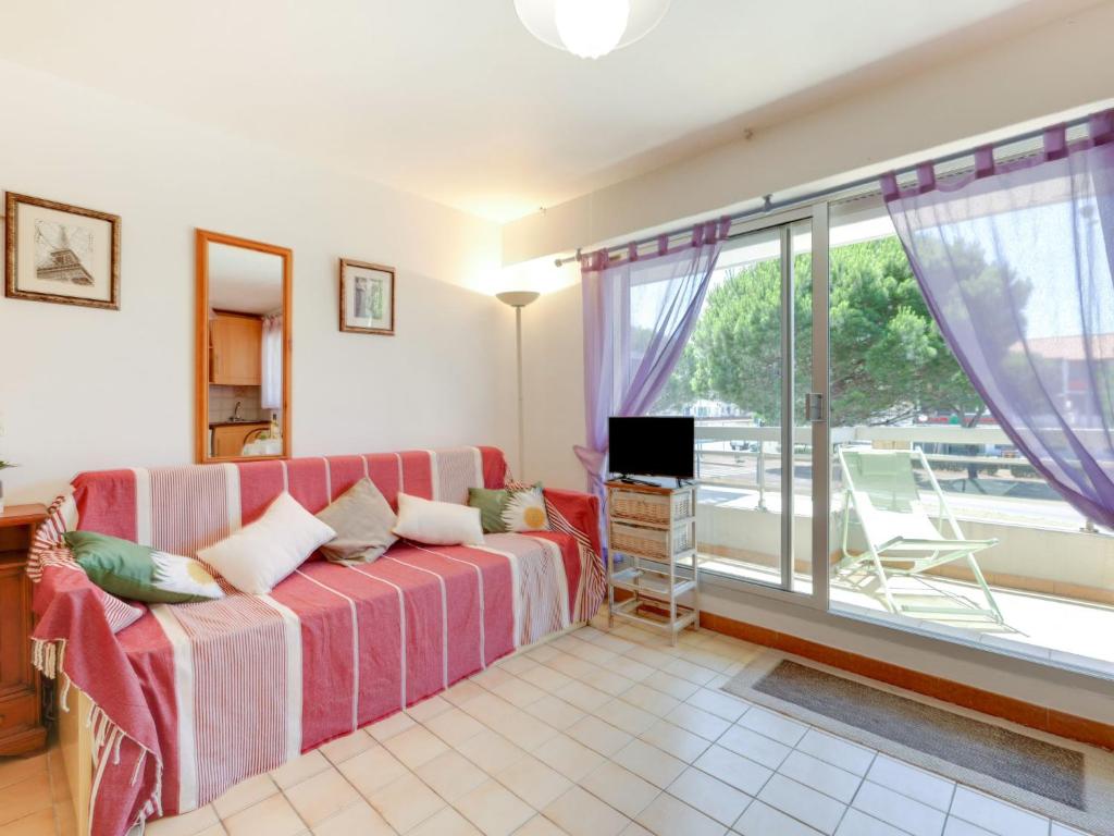 salon z kanapą i dużym oknem w obiekcie Studio Le Byblos by Interhome w mieście Saint-Cyprien-Plage