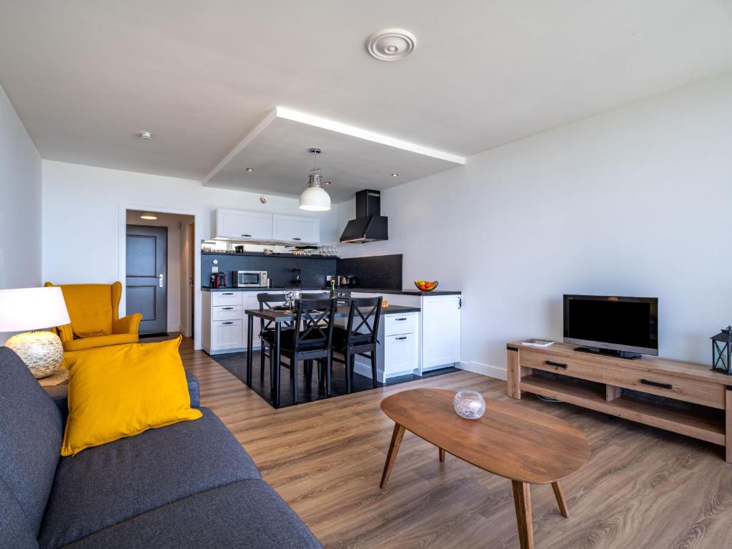 salon i kuchnia z kanapą i stołem w obiekcie Apartment Résidence Les Trois Iles by Interhome w mieście Quiberon