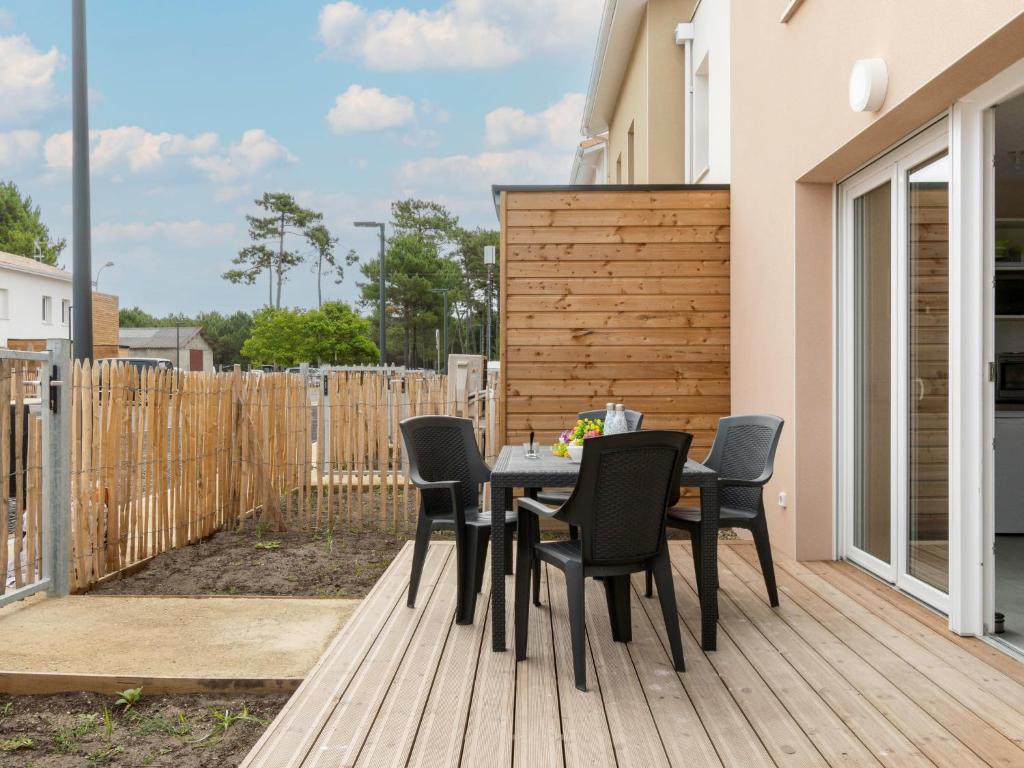 a patio with a table and chairs on a deck at Apartment SC C06 by Interhome in Mimizan