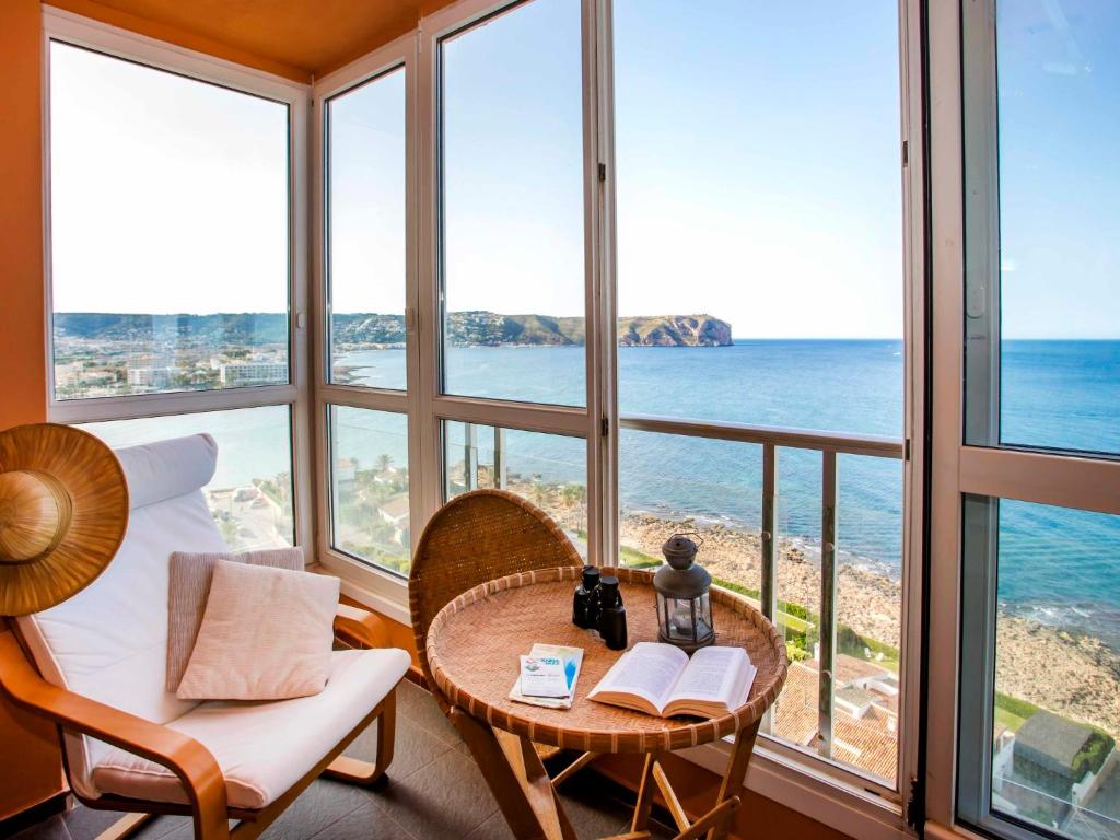 a room with a table and chairs and a view of the ocean at Apartment Torre del Castillo by Interhome in Jávea