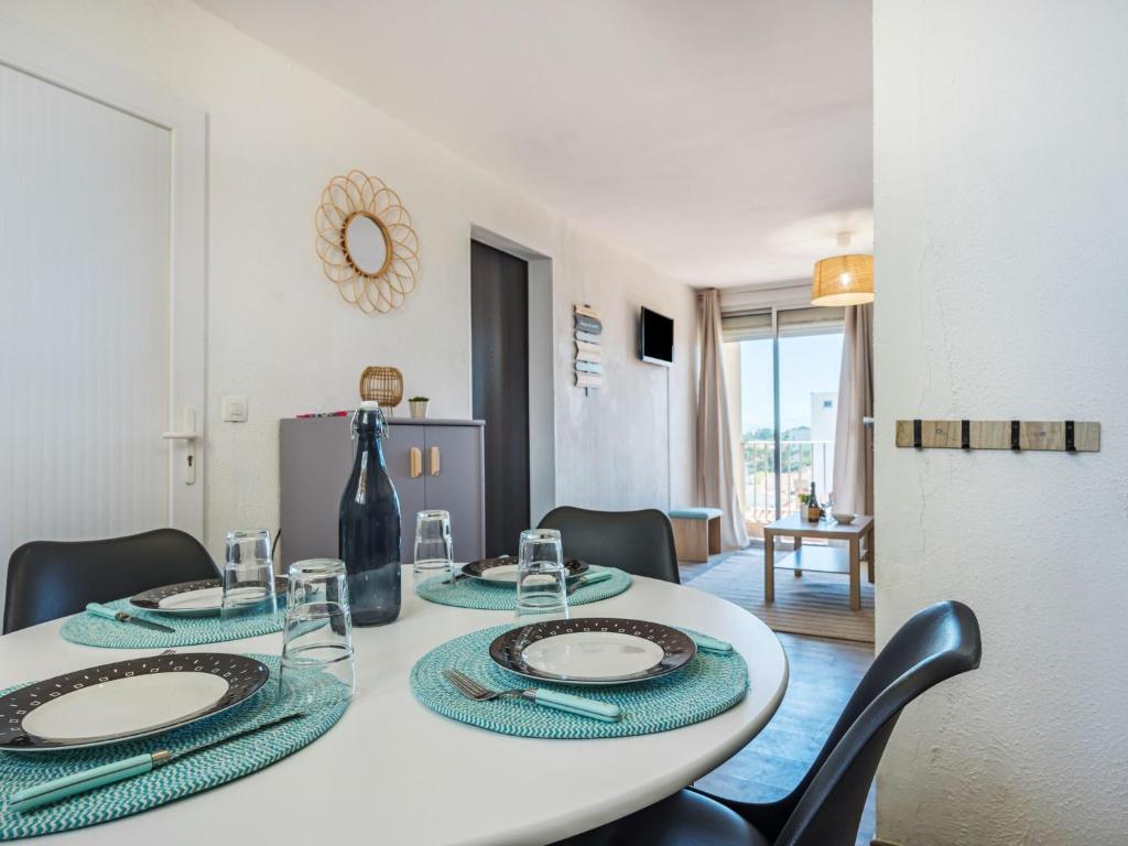 - une table blanche avec des chaises et une bouteille dans l'établissement Apartment Babel by Interhome, à Canet