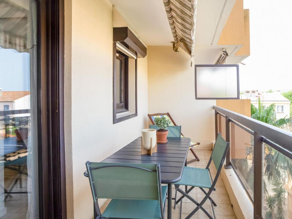 a balcony with a wooden table and chairs at Apartment Saint James-13 by Interhome in Le Lavandou