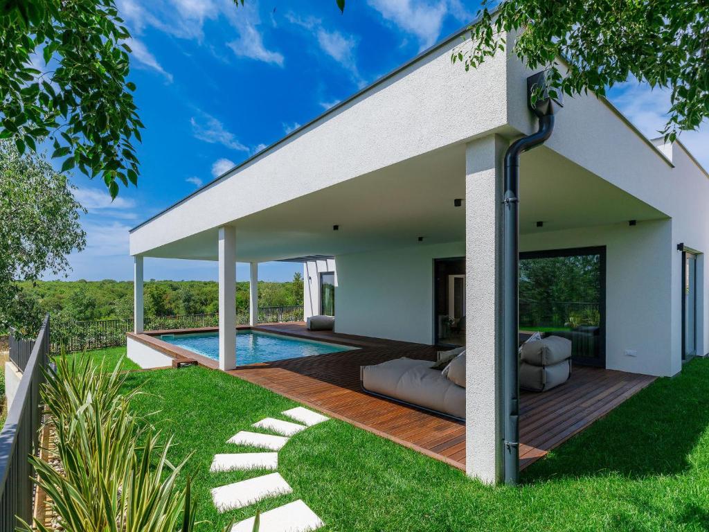eine Außenterrasse mit einem Pool und einem Haus in der Unterkunft Holiday Home Villa Valle by Interhome in Bale
