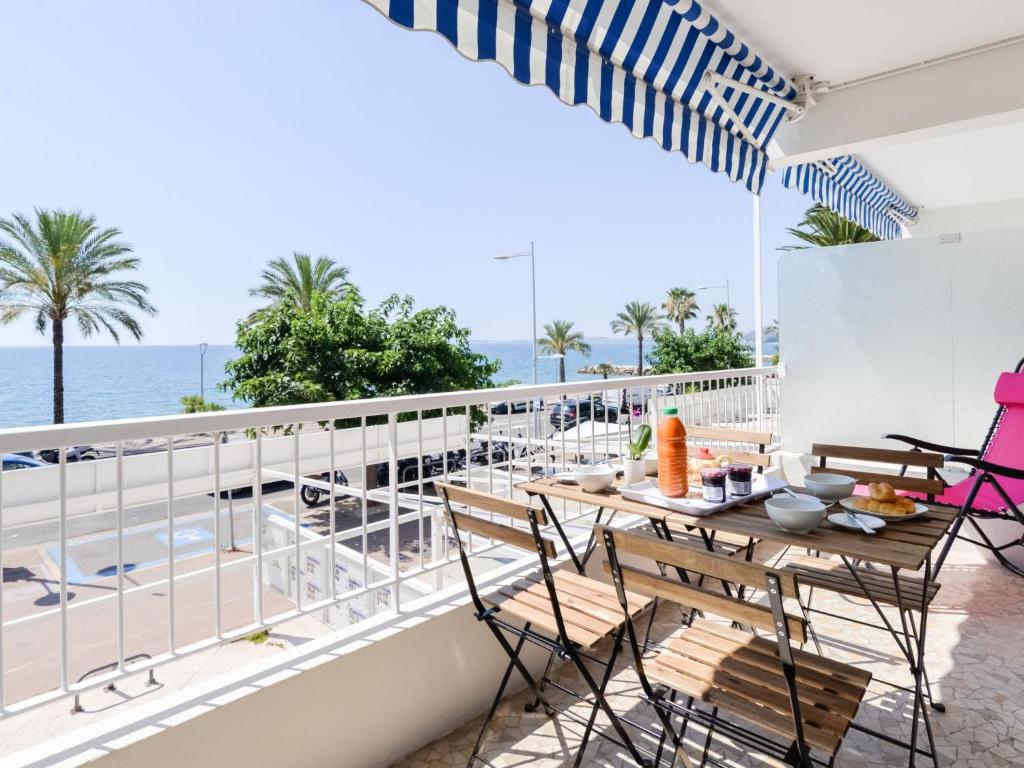 un balcon avec une table et des chaises et l'océan dans l'établissement Apartment Les Trois Caps by Interhome, à Cagnes-sur-Mer
