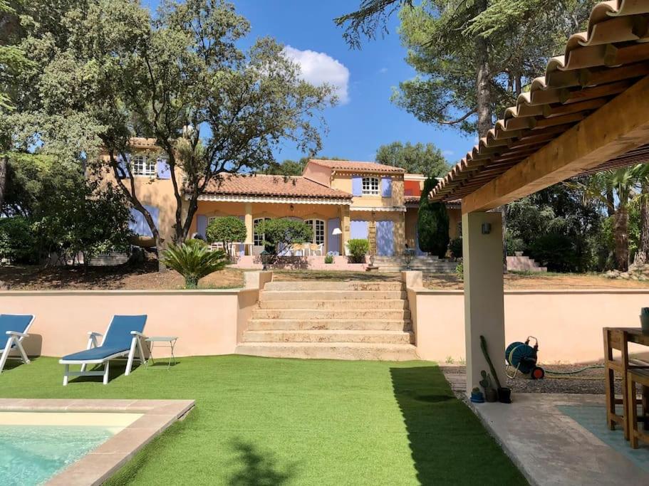 une maison avec une cour dotée d'une piscine et d'herbe dans l'établissement Villa Bois Romay dans le Luberon avec piscine, tennis et pétanque., à La Bastide-des-Jourdans