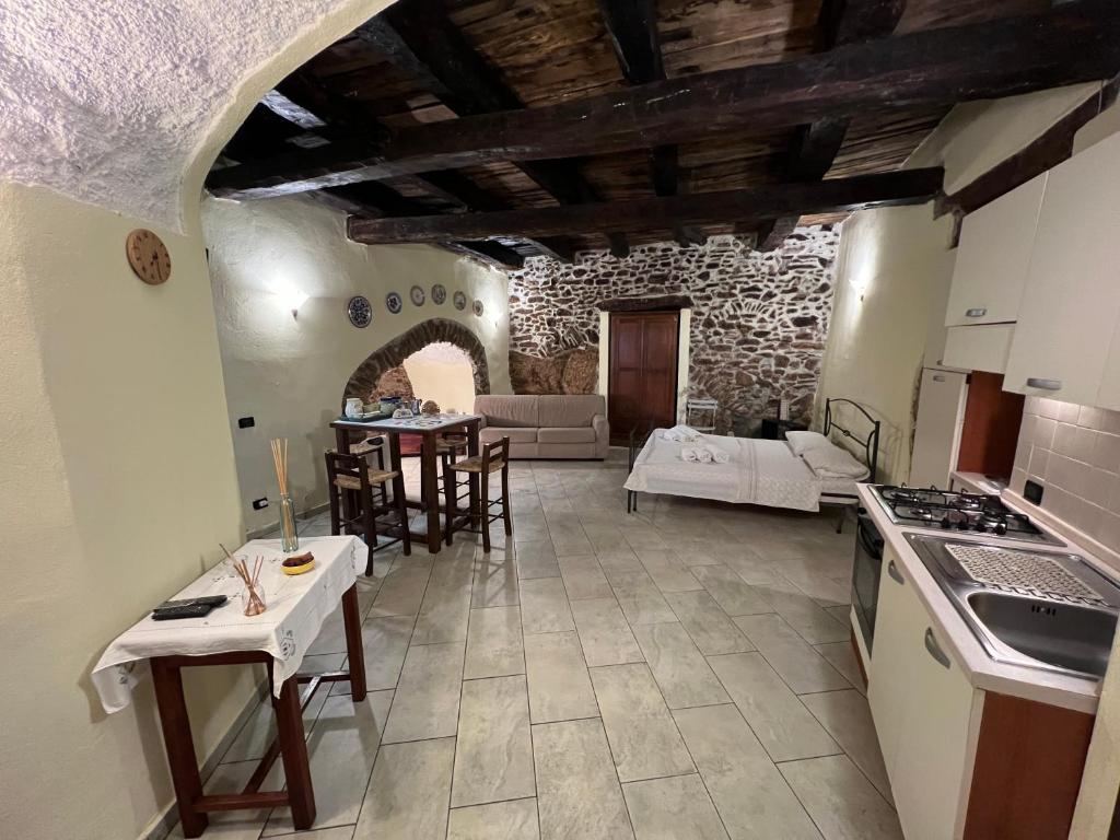 eine Küche und ein Wohnzimmer mit einem Sofa und einem Tisch in der Unterkunft La Cantina Di Nonno Ciccio in Fuscaldo