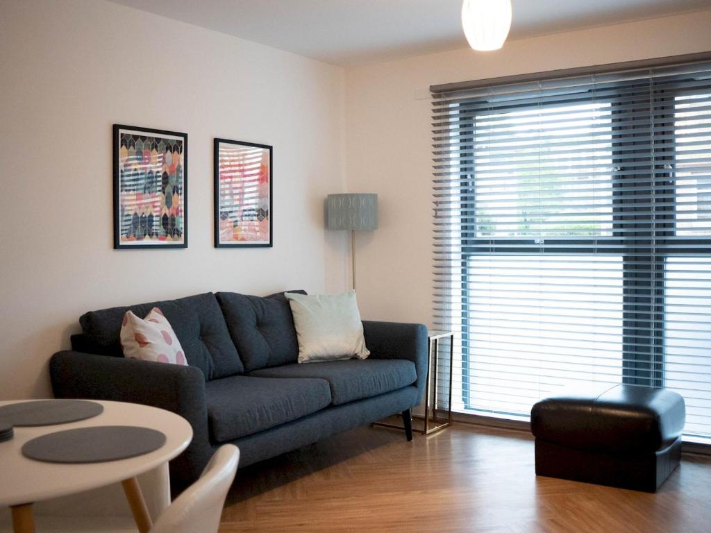 een woonkamer met een bank en een tafel bij Pass the Keys Lovely New 2-Bed SEC, Hydro, Finnieston with Parking in Glasgow