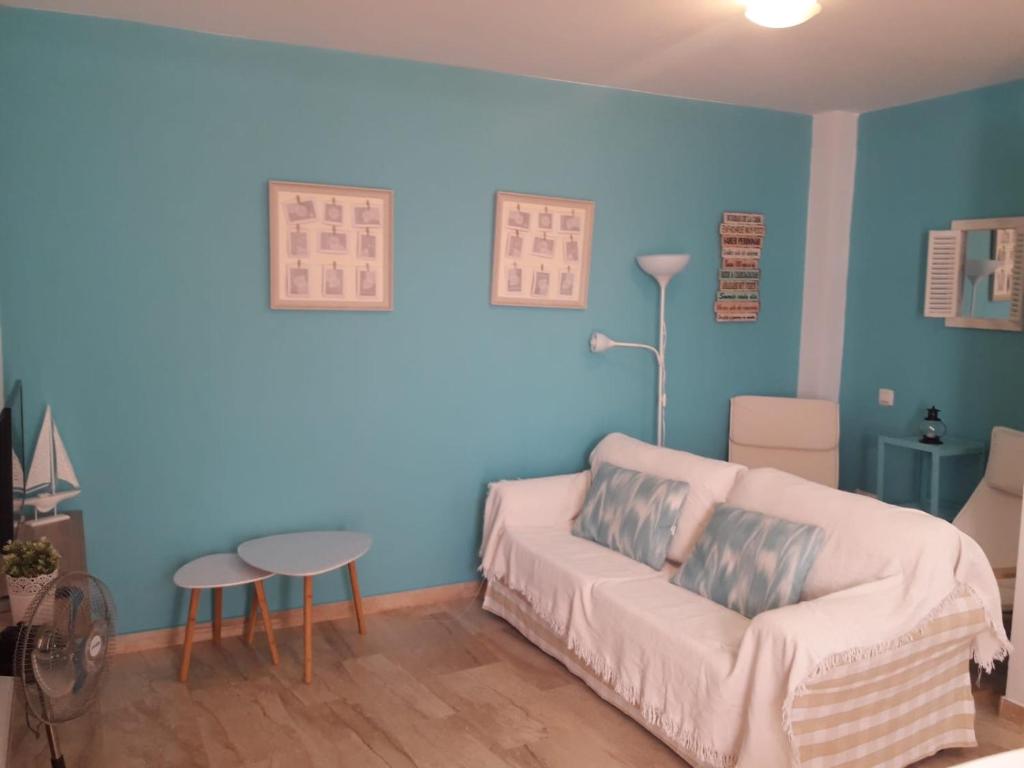 un soggiorno con pareti blu, divano e tavolo di El Ancla a Chiclana de la Frontera