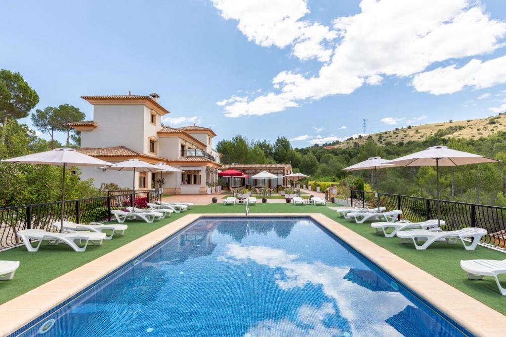 a villa with a swimming pool and lounge chairs at Hotel Finca Fabiola in Finestrat