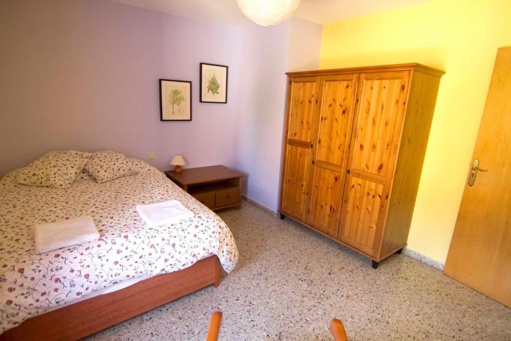 1 dormitorio con 1 cama y armario de madera en Casa Guaranatura alojamiento y barrancos en Bierge