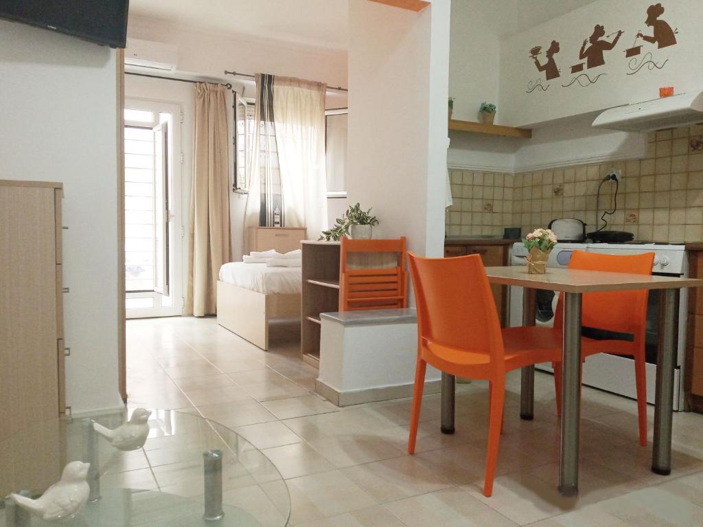 kuchnia i salon ze stołem i krzesłami w obiekcie Studio Victory Chania w Chanii