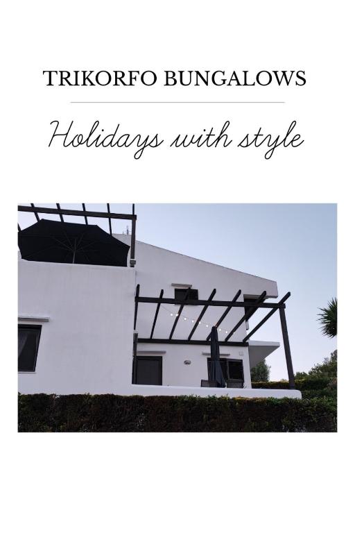 a picture of a white house with the words tichenore burrows holidays with at Trikorfo Bungalows in Gerakini