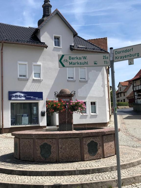 un letrero de la calle frente a un edificio blanco en Ferienwohnung Krayenbergblick en Bad Salzungen