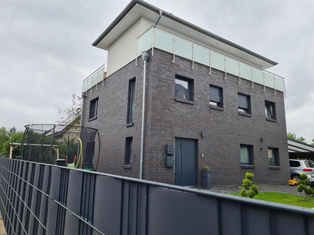 a brick building with a fence in front of it at Penthaus in Soltau