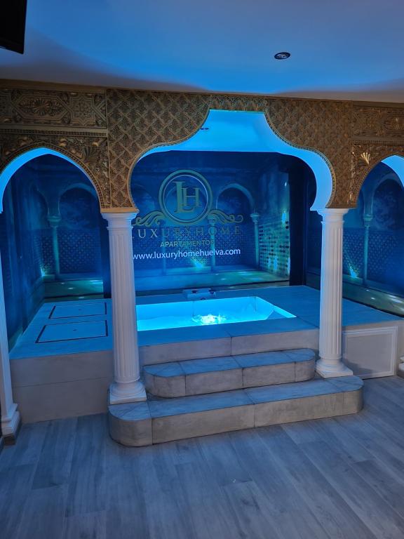una jacuzzi in una stanza con illuminazione blu di Apartamento Luxury Suite Huelva Zona Centro a Huelva