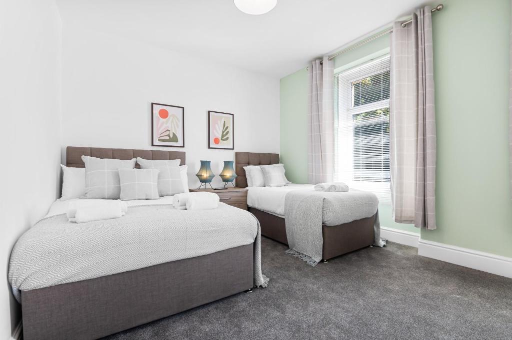 1 dormitorio blanco con 2 camas y ventana en Modern Tree View House- TV in every Bedroom!, en Morriston