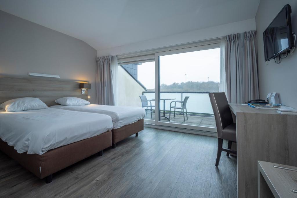 Postel nebo postele na pokoji v ubytování Fletcher Zuiderduin Beachhotel