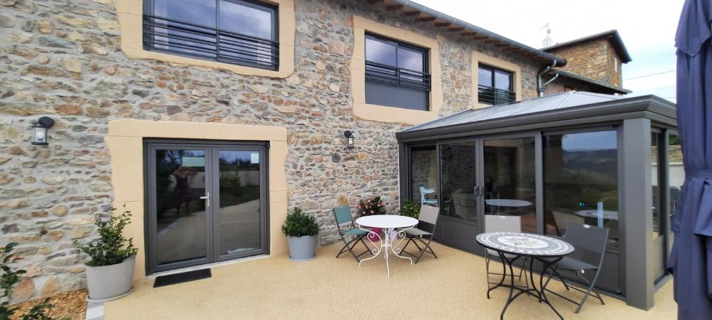 a patio with a table and chairs in front of a building at Bel Aujourd'hui Spa Sauna in Cordelle