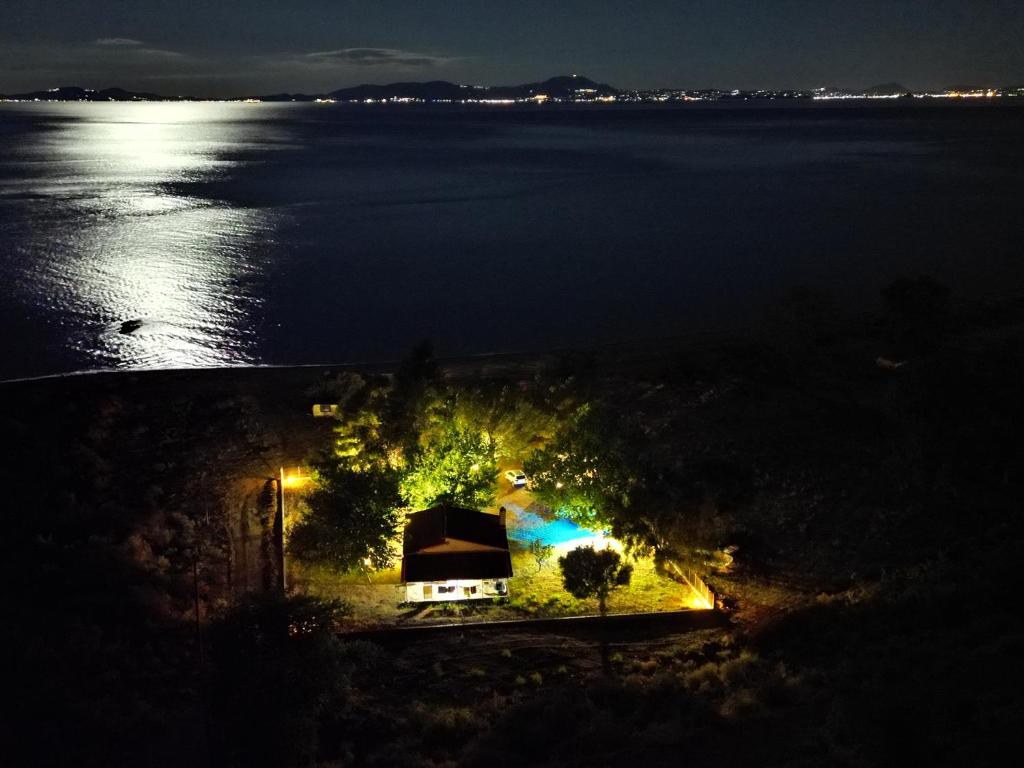 a house on the shore of a lake at night at Κτήμα Basios D. in Sagiada