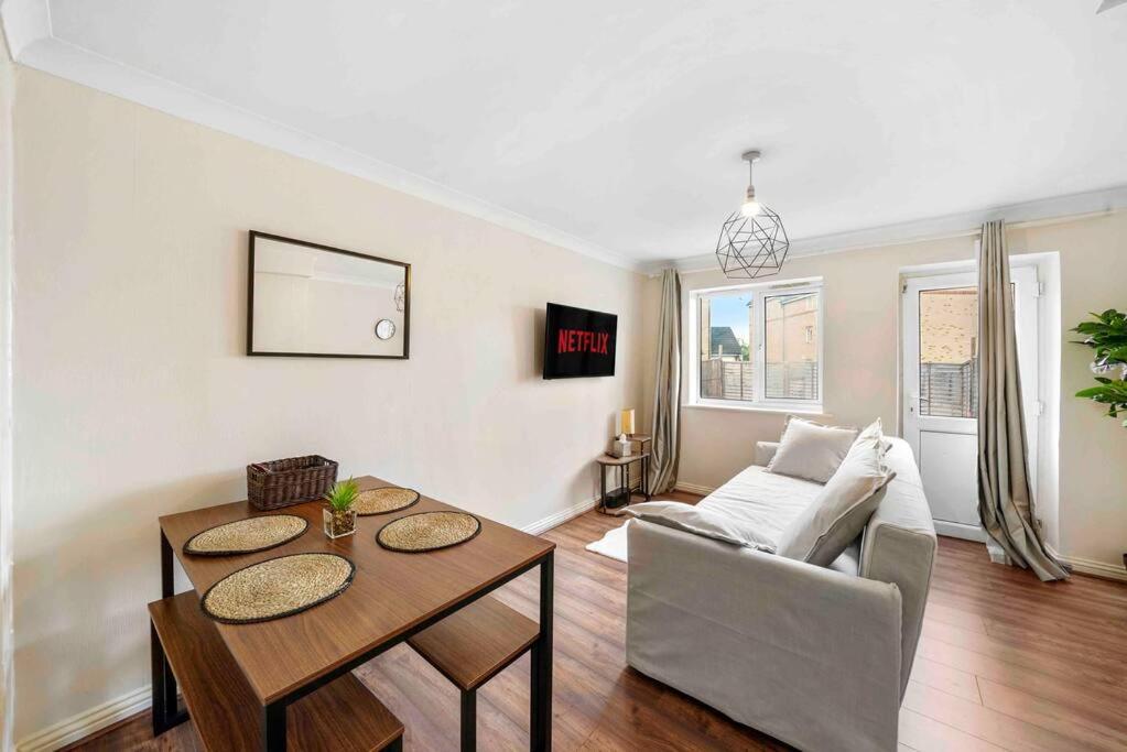 a living room with a table and a couch at ◑4 Bed Townhouse◑10guests◑ Garden◑Wifi & Netflix◑ in Thamesmead