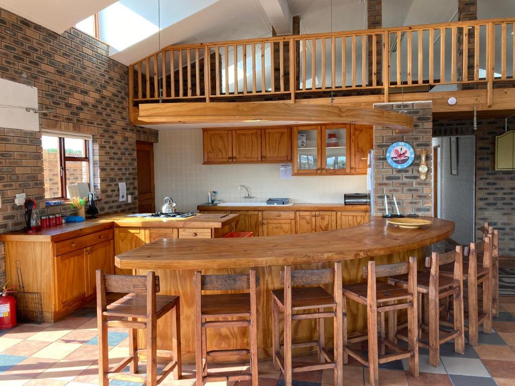 eine Küche mit einem großen Holztisch und Stühlen in der Unterkunft Net Net Holiday Home in Witsand