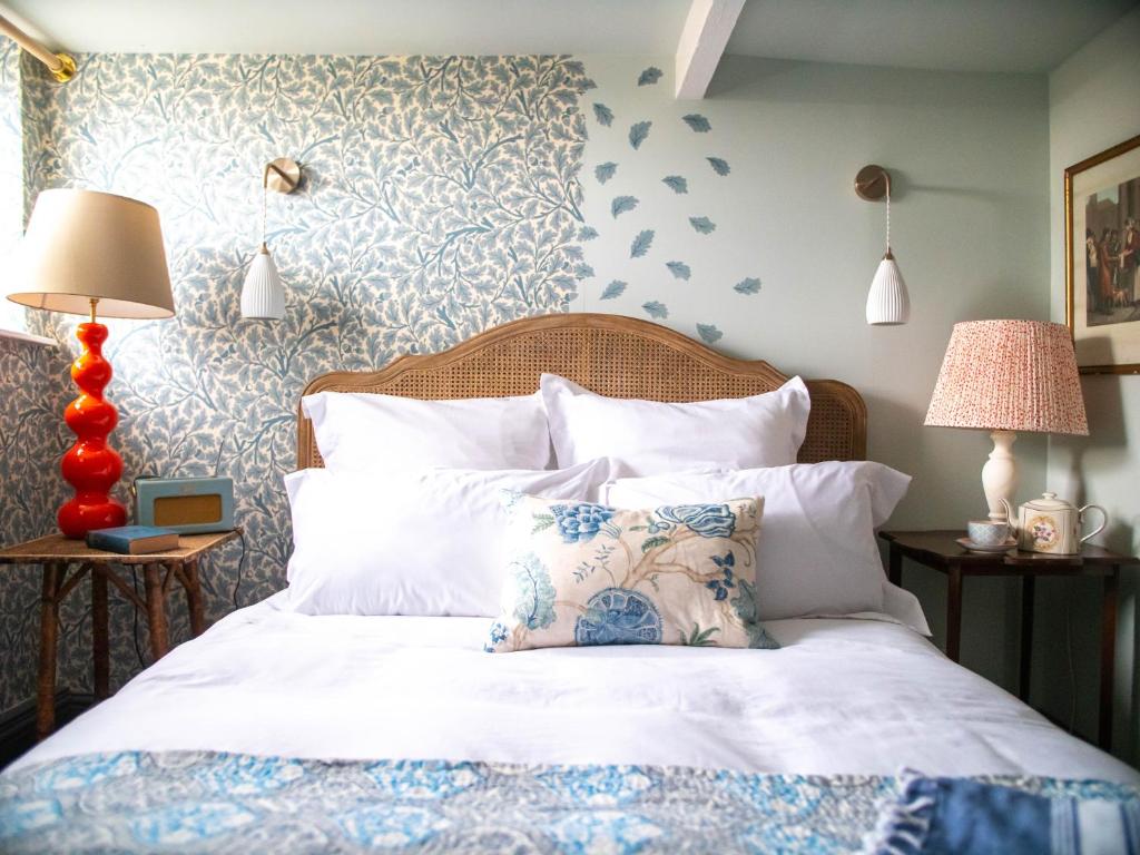 a bedroom with a white bed with a blue and white wall at Country Cottage with Spa, Catering, Gardens, Nature Reserve Walks - Free Parking, Self Checkin in Scunthorpe