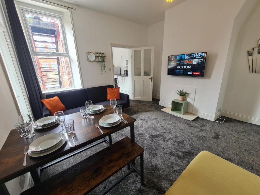 a living room with a dining table and a couch at 5 bed sleeps 6, 2 miles (7 mins) from city centre in Low Team